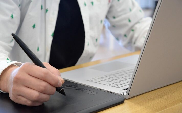 Imagem de pessoa fazendo uso de um computador e uma mesa digitalizadora