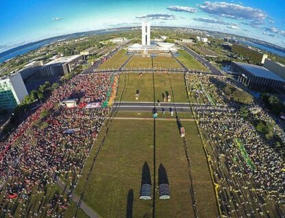 Imagem aérea da frente do Congresso Nacional, em Brasília, no dia da votação de impeachment de Dilma Rousseff; à esquerda, grande grupo de pessoas de vermelho e, à direita, grande grupo de pessoas vestidas de verde e amarelo, separadas por um canteiro central