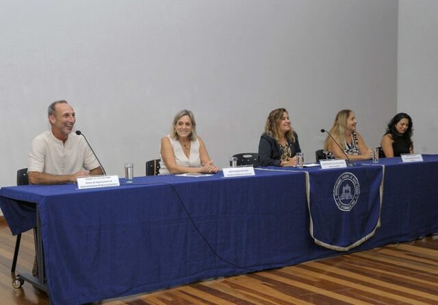 Imagem mostra Sandra Goulart, Márcia Machado e outros representantes da PRORH sentados em uma mesa durante recepção aos servidores