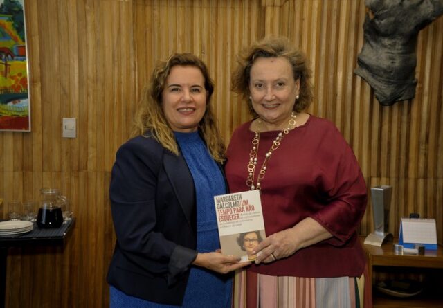 Imagem mostra retrato Sandra Goulart e Margareth Dalcolmo segurando, juntas, exemplar de livro da própria pesquisadora da Fiocruz