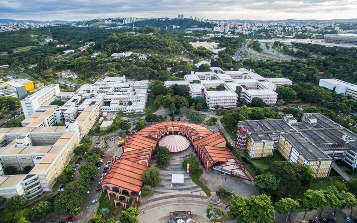 Imagem mostra vista aérea do campus Pampulha da UFMG, com praça de serviços ao centro